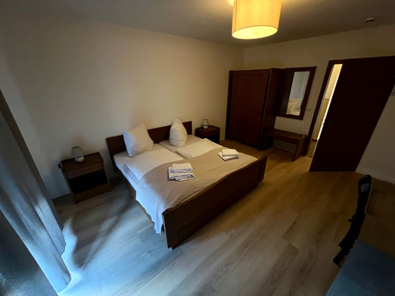 Zimmer 2: Doppelbett mit Nachttischen und Kleiderschrank